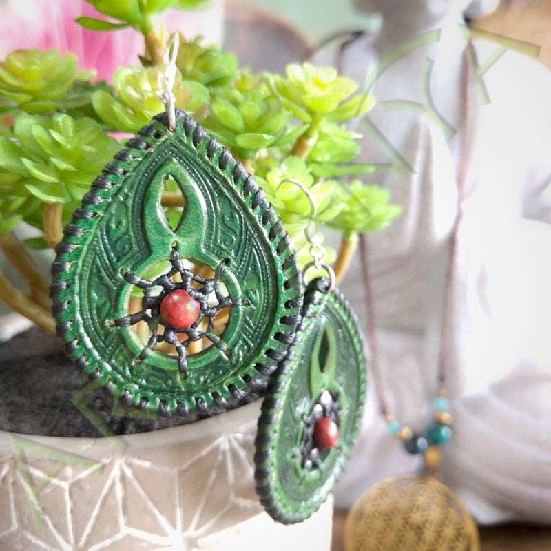 vue d'ensemble sur un pot de fleur de la paire de boucles d'oreille en cuir ethnique attrape rêve verte avec perle en bois
